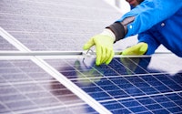 Close up of man with tools maintaining photovoltaic solar panels
