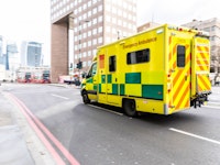 Emergency ambulance rushing on the street with emergency lights flashing in London city centre.