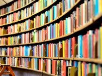Round bookshelf in public library with multi-coloured books