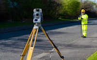 Site engineer doing road survey using modern robotic total station