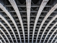 Symmetric steel framework under a bridge over the river Thames in London.